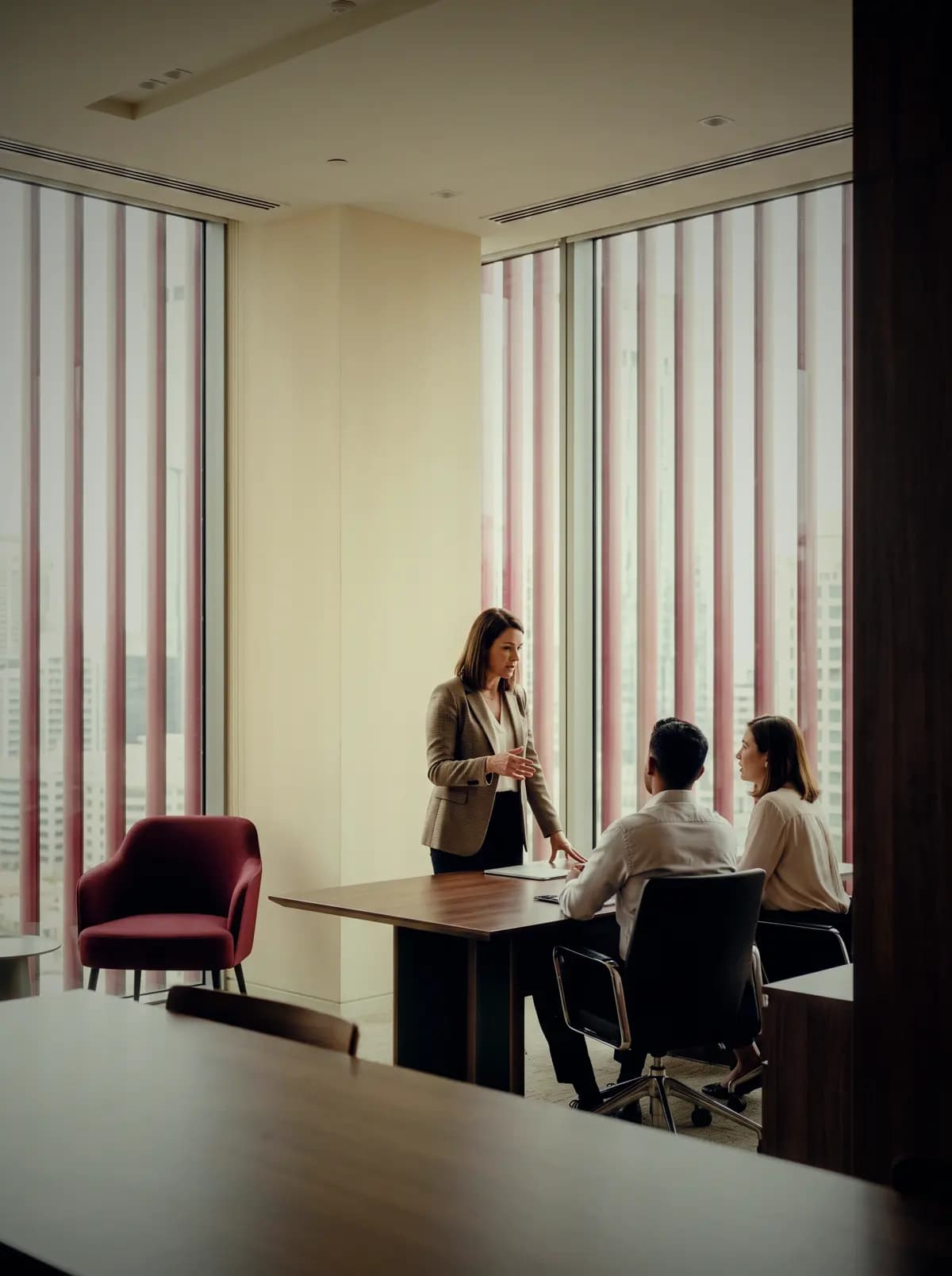 A meeting underway in an office at VARA Plaza, the fin-shaded facade beyond the glass.
